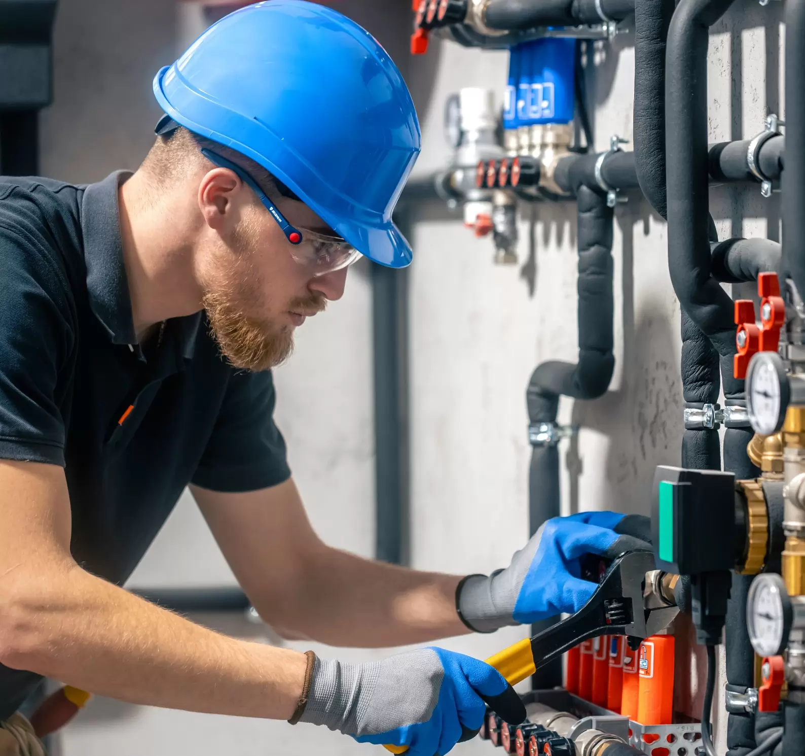 man-installs-heating-system-house-checks-pipes-with-wrench